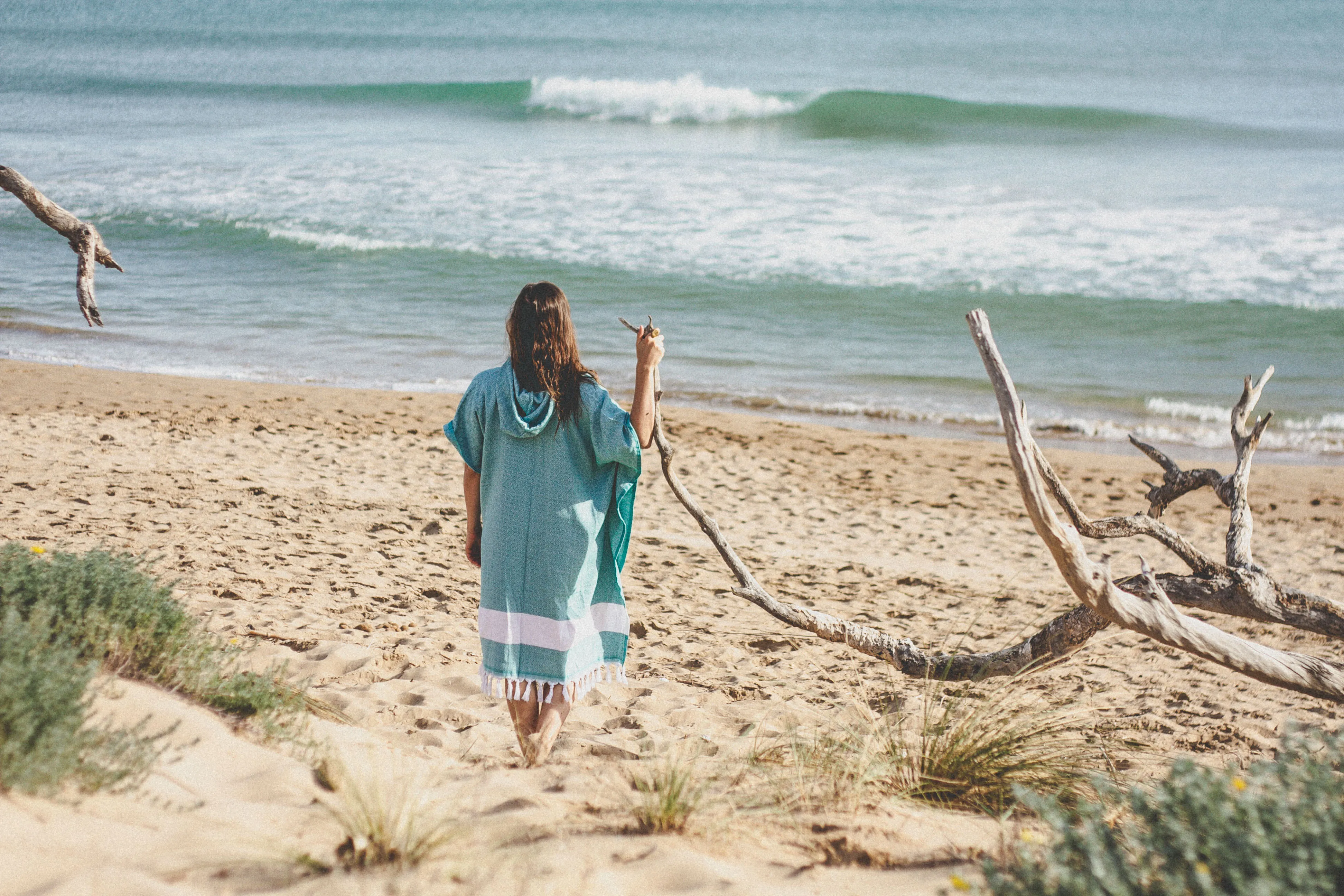 Jenn am Meer, in handgewebtem Surfponcho